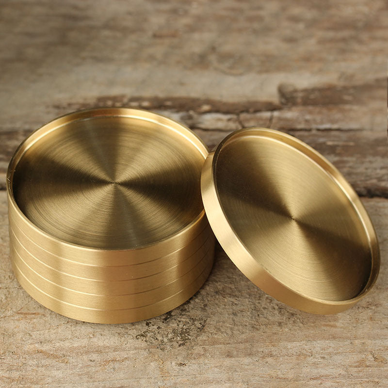 Five solid brass coasters for drinks.