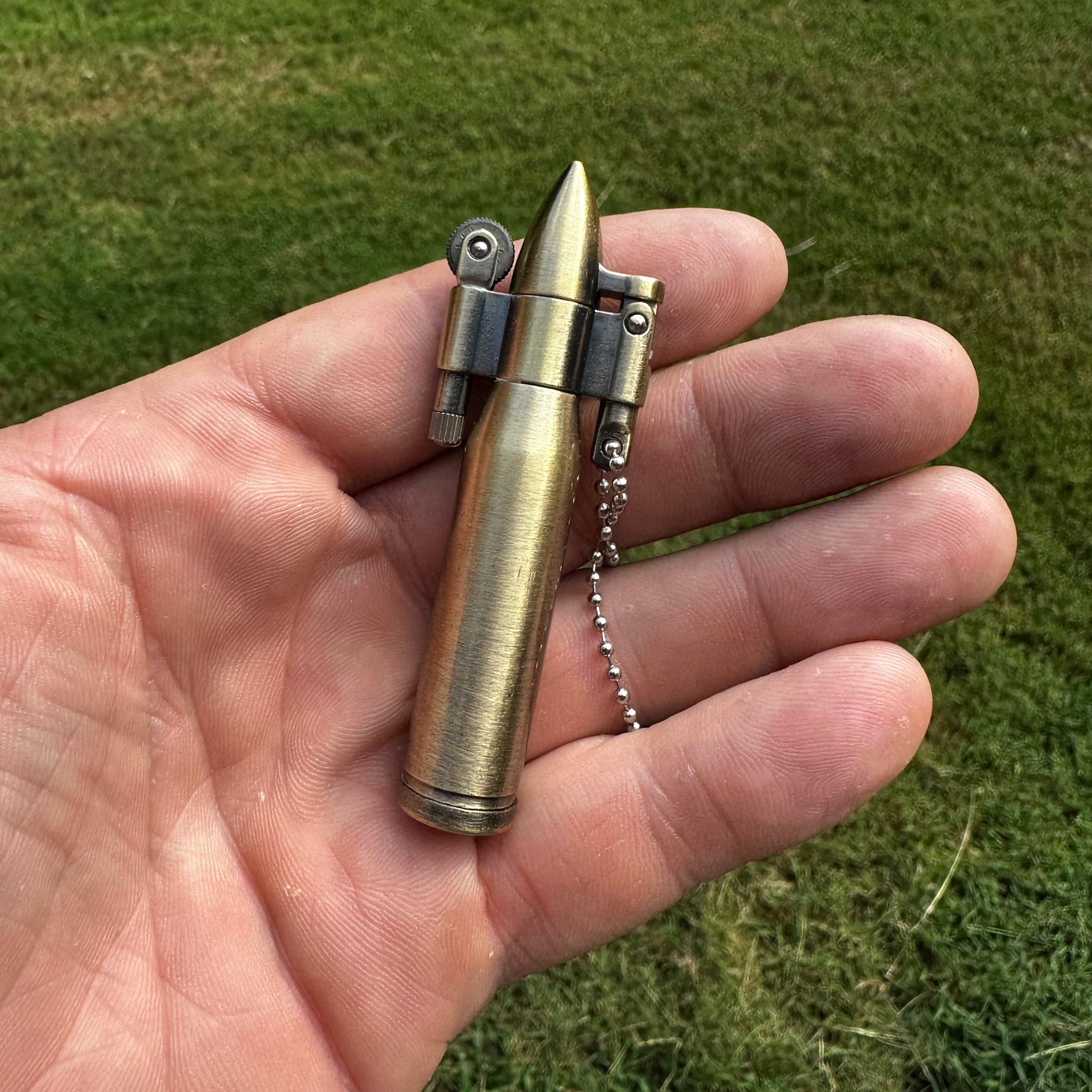 A portable brass gold bullet kerosene lighter keychain.