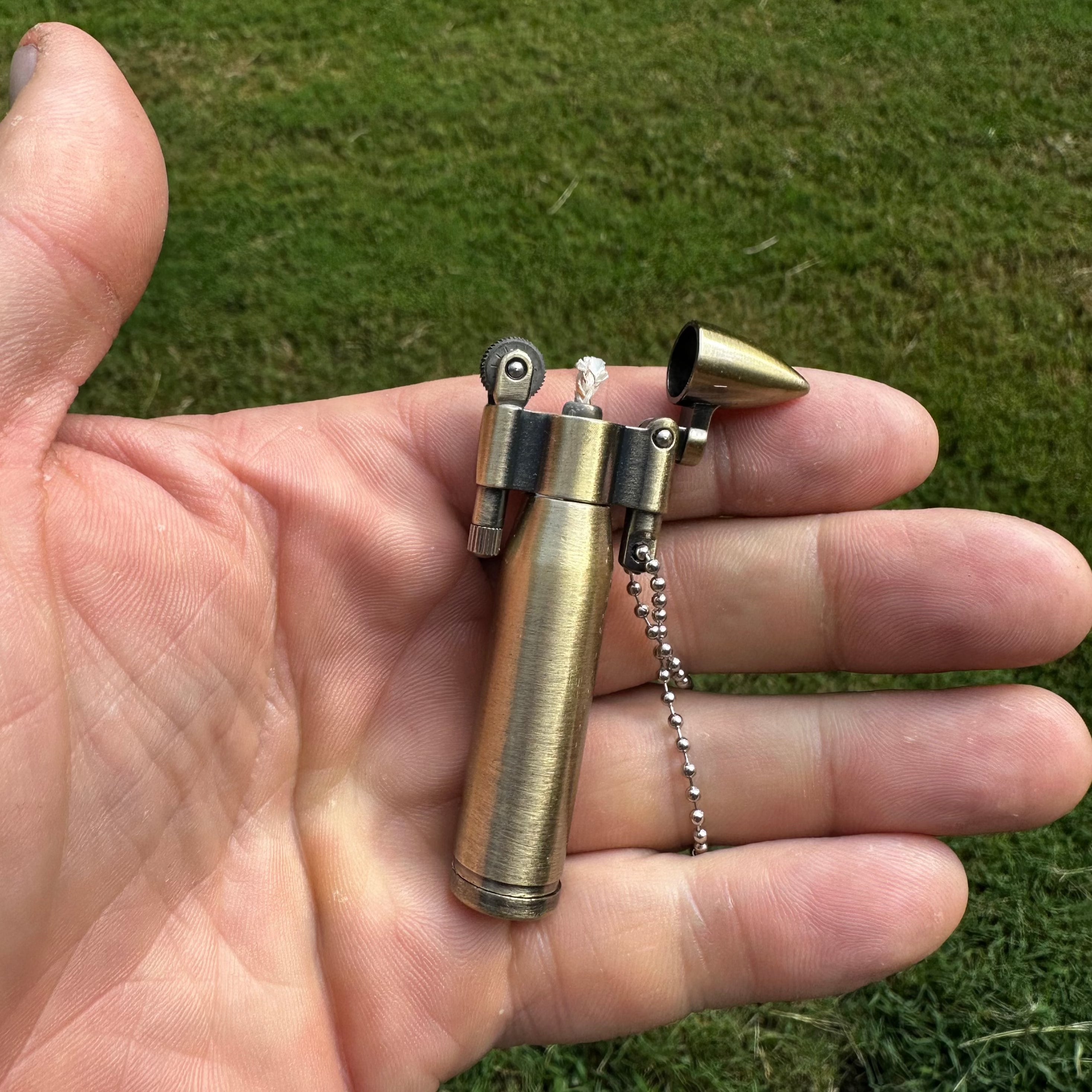 A portable brass gold bullet kerosene lighter keychain.