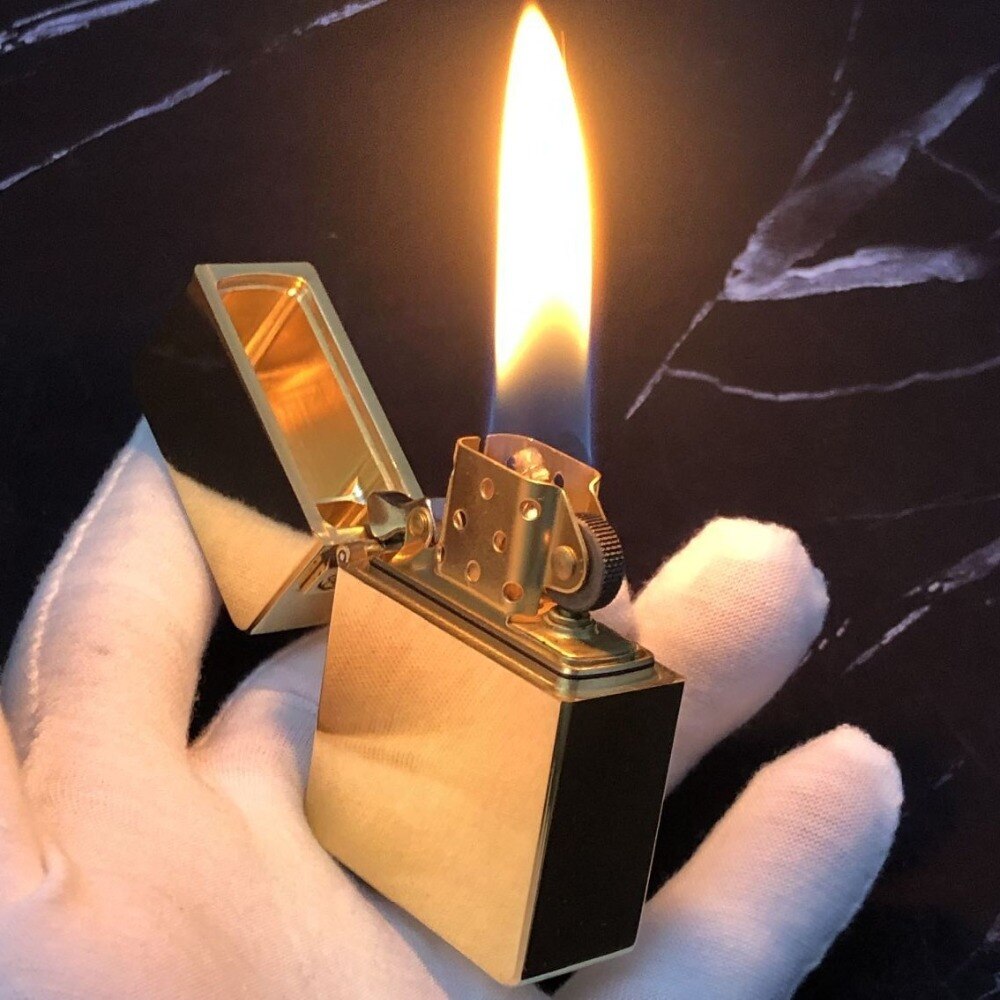 A gold brass lighter being used.