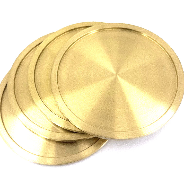 Four solid brass coasters for drinks.