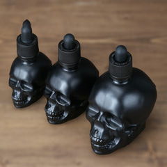 Three sizes of a black skull dropper.