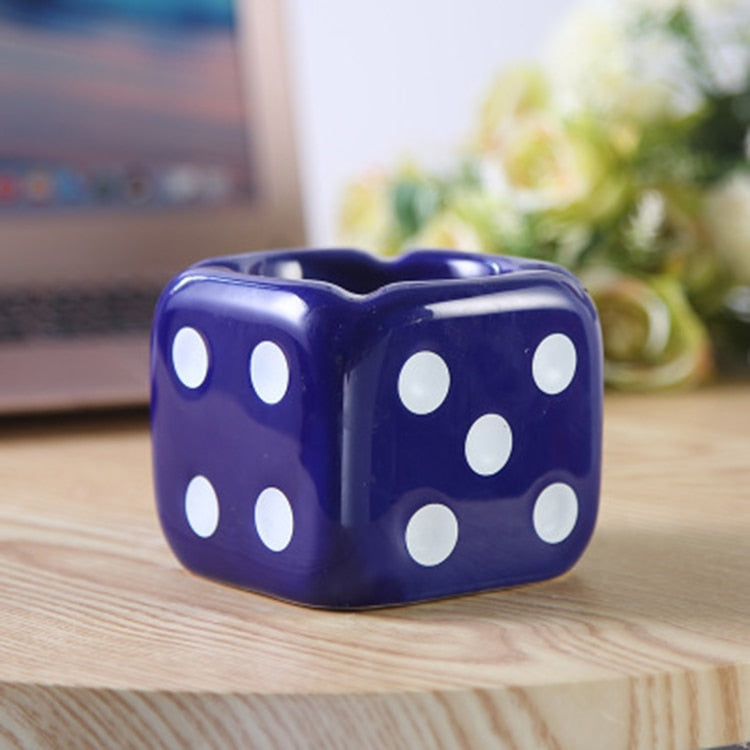 Blue dice ashtray with white dots on the table.
