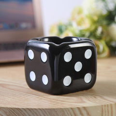 Black dice ashtray on the table.