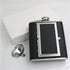 A black whiskey flask with a cigarette compartment and a white package box.
